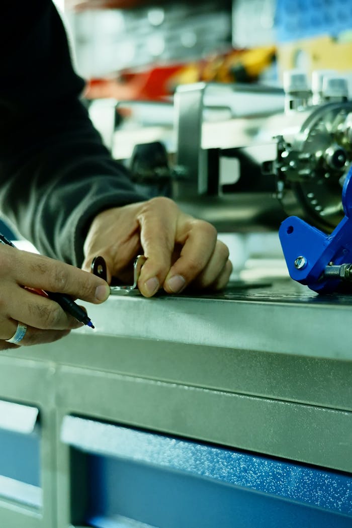 Close-up of hands measuring with tools in a mechanical workshop, focusing on precision.