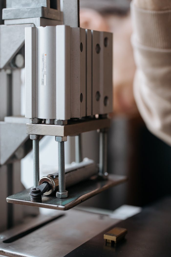 Detailed view of a stainless steel machine with screws and nuts, highlighting industrial machinery.